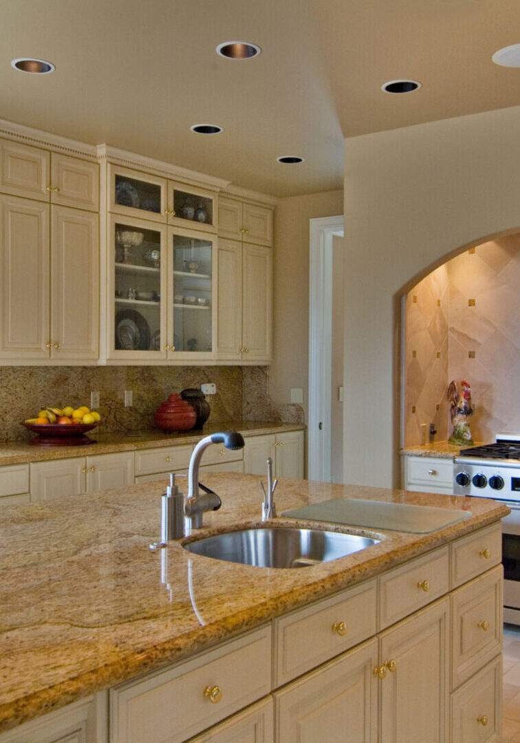 A kitchen with white cabinets and granite counter tops.