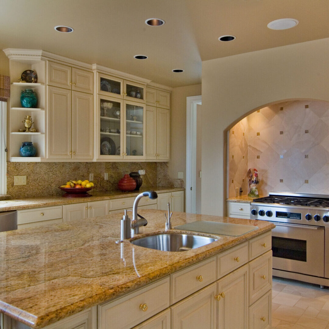 A kitchen with white cabinets and granite counter tops.